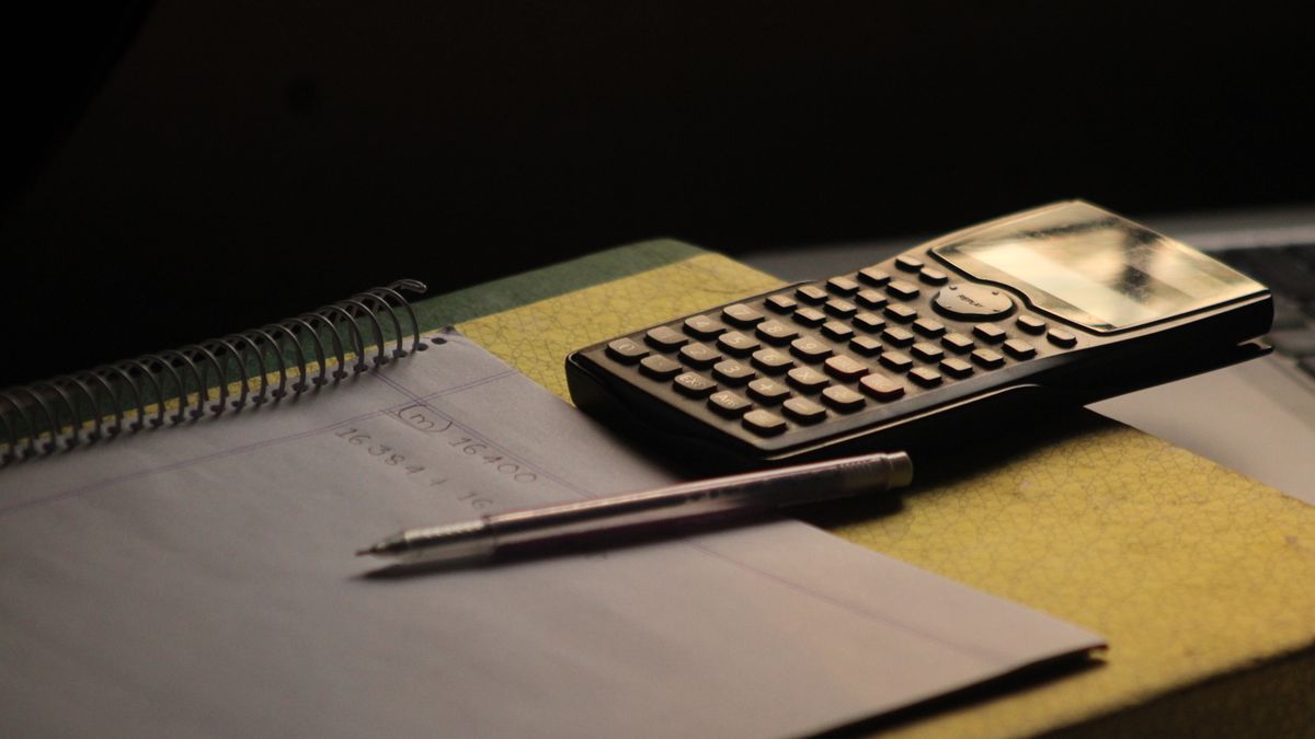 Calculatrice et carnet posés sur un bureau