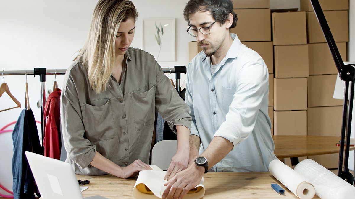 Deux personnes emballant un produit sur une table