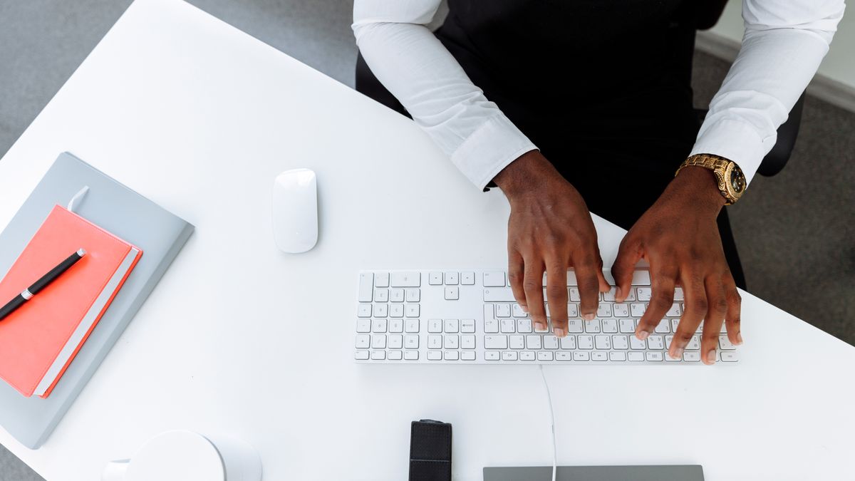 Personne utilisant un clavier sur un bureau